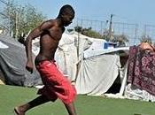 enfants d'Haïti jouent football dans stade deve...